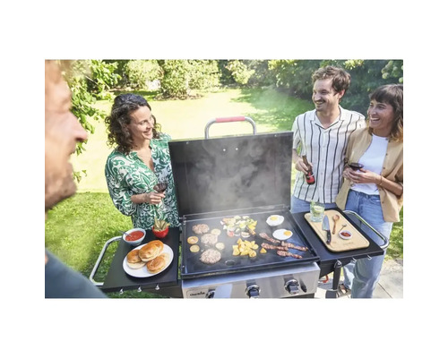Oameni care fac grătar hamburgeri și legume pe o plită în grădină.