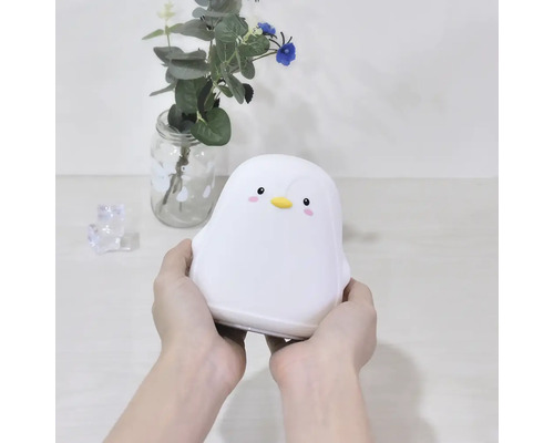 Lampă pinguin albă ținută în mâini