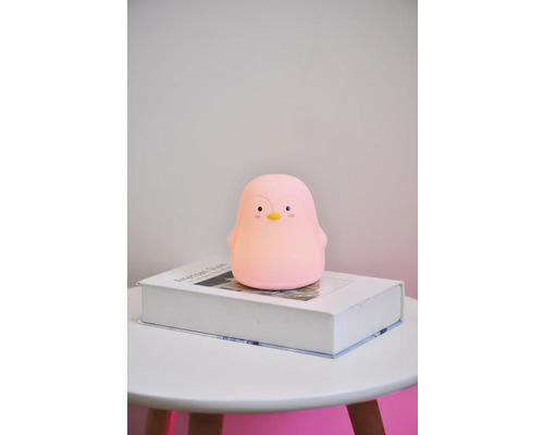 Lumină de noapte în formă de pinguin pe o carte