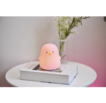 Lumină de noapte pinguin pe o carte pe o masă