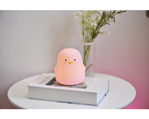 Lumină de noapte pinguin pe o carte pe o masă