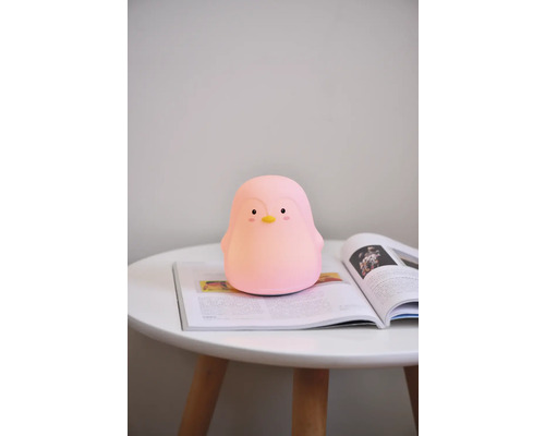 Lumină de noapte pinguin pe o masă cu revistă