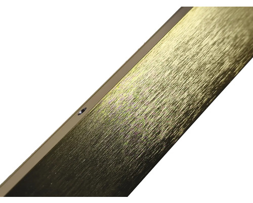 Prim-plan al unui profil metalic auriu cu finisaj periat și orificiu de găurire