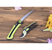 Fierăstrău de grădină și foarfecă de grădinărit pe fundal de lemn