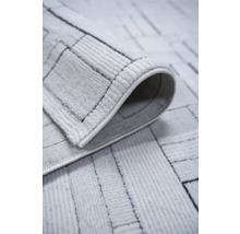 Prim-plan al unui covor deschis la culoare cu model geometric