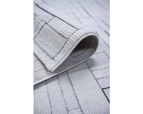 Prim-plan al unui covor deschis la culoare cu model geometric