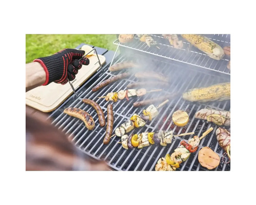 Scenă de grătar cu cârnați, legume și o persoană cu mănușă de grătar