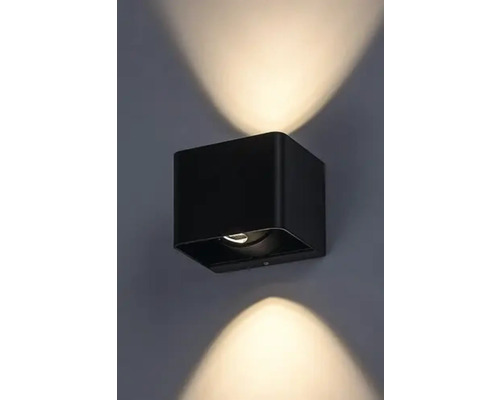 Lumină de perete neagră, în formă de cub, cu raze de lumină în sus și în jos.