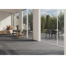 Cameră luminoasă cu gresie cu aspect de marmură, mobilier și vedere spre grădină