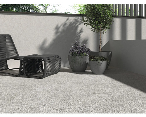 Terasa cu gresie de podea, locuri de ședere și plante în ghivece