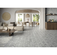 Living luminos cu podea cu gresie în model herringbone, canapea, masă de sufragerie și decorațiuni.