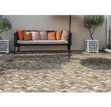 Terasa cu model de cărămidă, bancă cu perne și ghivece decorate și plantate.