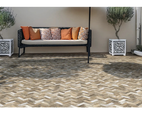 Terasa cu model de cărămidă, bancă cu perne și ghivece decorate și plantate.