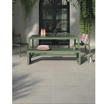 Spațiu exterior cu masă de grădină verde și scaune pe podea cu gresie