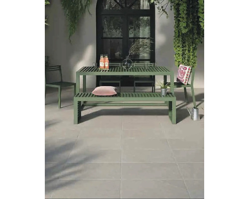 Spațiu exterior cu masă de grădină verde și scaune pe podea cu gresie