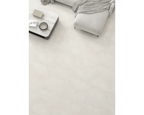 Montare de gresie de pardoseală într-un living luminos cu canapea și masă