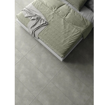 Pat cu lenjerie de pat pe gresie