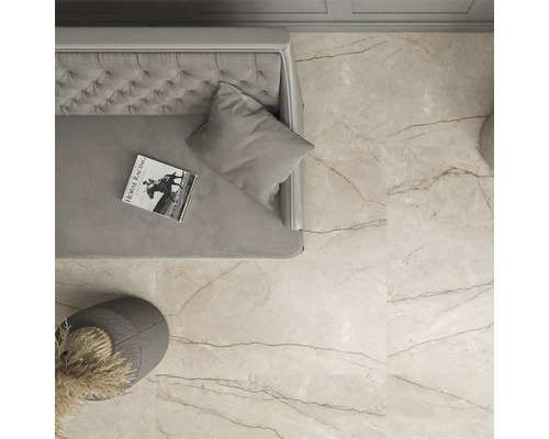 Vedere cu gresie în sufragerie cu canapea, pernă, carte și decorațiuni