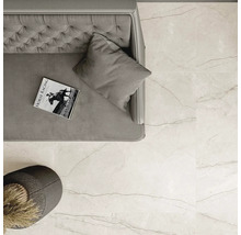 Prim-plan detaliat al unei camere cu gresie de pardoseală deschisă la culoare cu aspect de marmură, canapea și măsuță laterală.