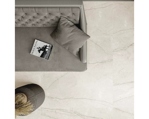 Prim-plan detaliat al unei camere cu gresie de pardoseală deschisă la culoare cu aspect de marmură, canapea și măsuță laterală.