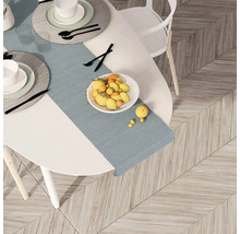 Masa cu veselă, bol cu fructe și față de masă pe o podea de lemn