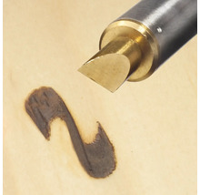 Aparat de pirogravat creând o linie întunecată pe lemn