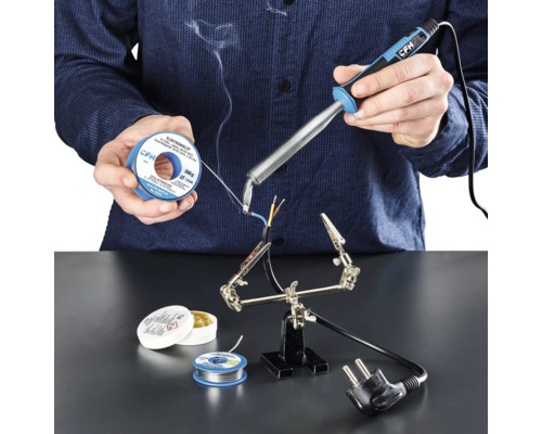 Ciocan de lipit tip letcon CFH E100 100W, vârf îndoit O persoană sudează cabluri cu un pistol de lipit, cositor de lipit și flux de lipit pe o suprafață de lucru.