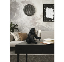 Lampă decorativă gorilă pe o masă într-o cameră de zi