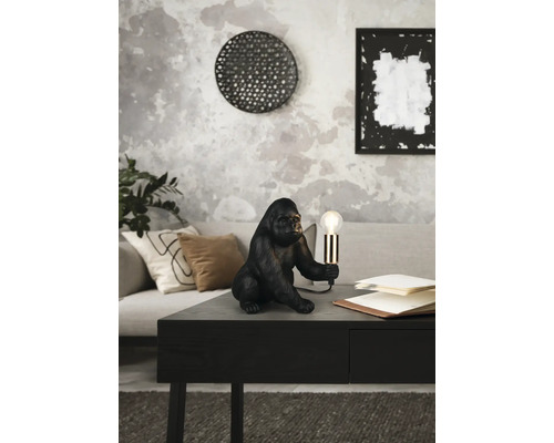 Lampă decorativă gorilă pe o masă într-o cameră de zi