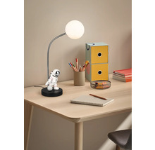 Lampă de masă cu figurină astronaut pe un birou