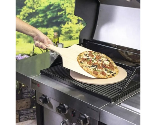 Pizza pe lopată de lemn deasupra pietrei de pizza pe grătar