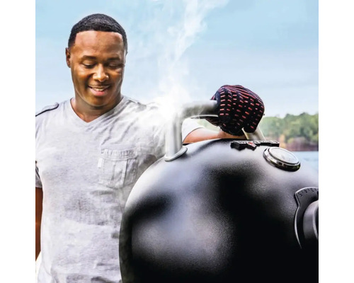 Bărbat folosind grătar sferic cu termometru și regulator de aer în aer liber