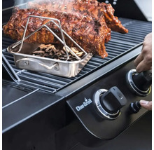 Grătar cu coaste, cutie de afumare și așchii de lemn și o mână pe un buton rotativ