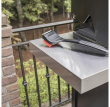 Perie de grătar pe o masă laterală a unui grătar