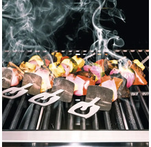 Frigărui de legume cu suporturi pe un grătar cu degajare de fum