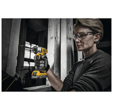 O persoană folosește o șurubelniță cu impact fără fir DeWalt pe un șantier.