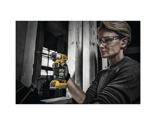 O persoană folosește o șurubelniță cu impact fără fir DeWalt pe un șantier.