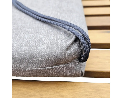 Prim-plan cu o pernă de șezut gri cu șnur pe o bancă de lemn