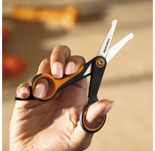 Mână ținând o foarfecă mică marca Fiskars