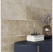 Plăci de perete bej cu bandă decorativă, combinate cu o piesă de mobilier închisă la culoare, un vas transparent de sticlă cu flori, cărți și o lumânare.