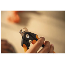 Mâini care țin un clește de gheare pentru animale de companie