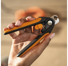 Mâna ține o pereche de foarfeci de unghii pentru animale cu mânere