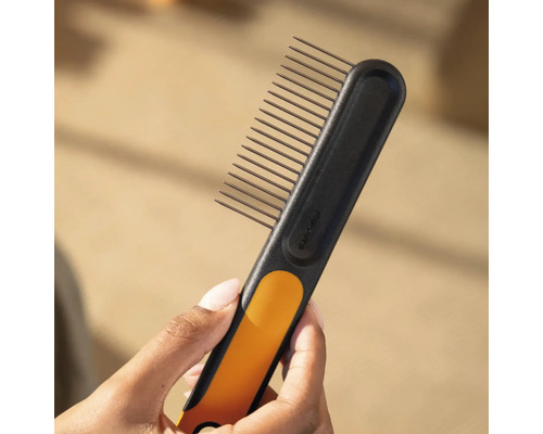 Sigla Fiskars. O mână ține o greblă neagră Fiskars cu dinți.