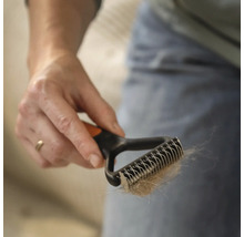 Mână ținând o perie pentru păr de animale cu păr de animale