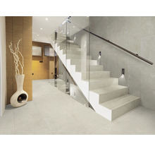 Intrare luminoasă cu scară din piatră, balustradă din sticlă și gresie ceramică.