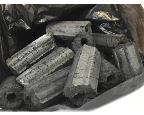 Brichete hexagonale din cărbune de lemn cu gaură în mijloc pentru grătar într-un sac.