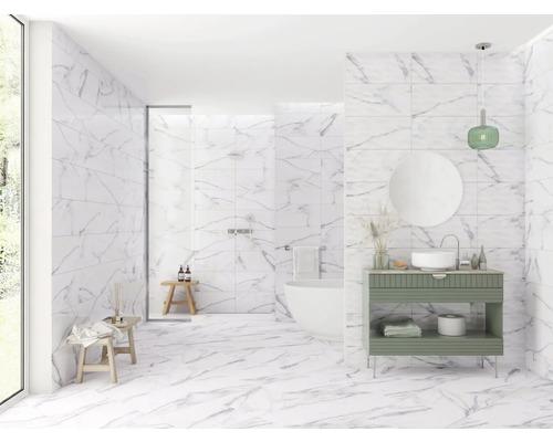 Baie luminoasă cu gresie de marmură pe pereți și podea, dulap de chiuvetă, cadă și duș.