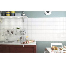 Bucătărie cu faianță albă, chiuvetă și masă de sufragerie