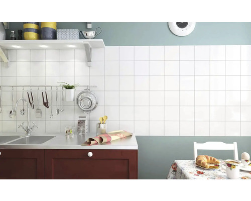 Bucătărie cu faianță albă, chiuvetă și masă de sufragerie