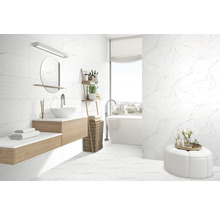 Baie modernă cu gresie de marmură albă pe pereți și podea, lavoar cu oglindă și cadă.